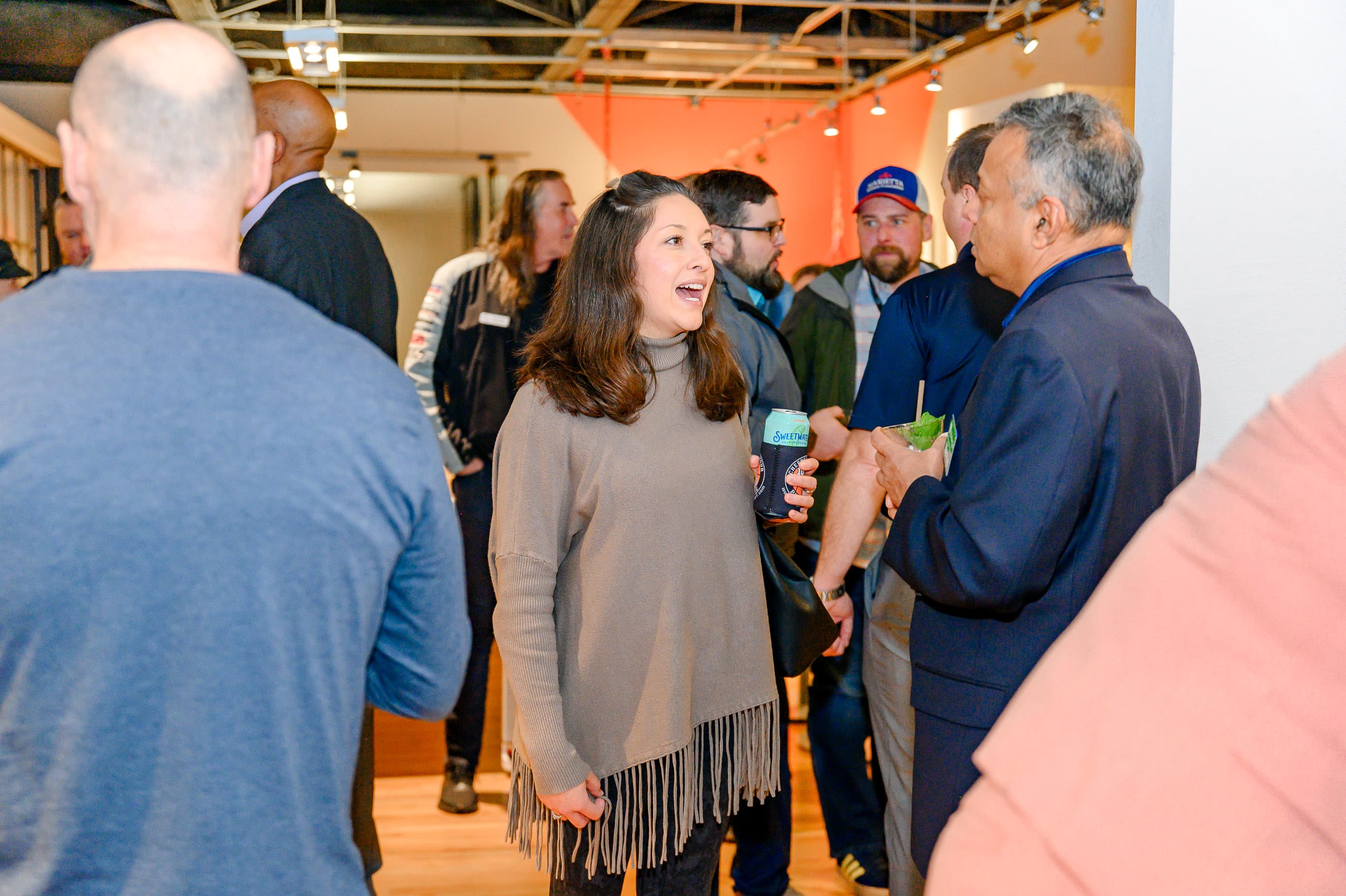 Guests networking and enjoying refreshments at a social event in a modern coworking space.