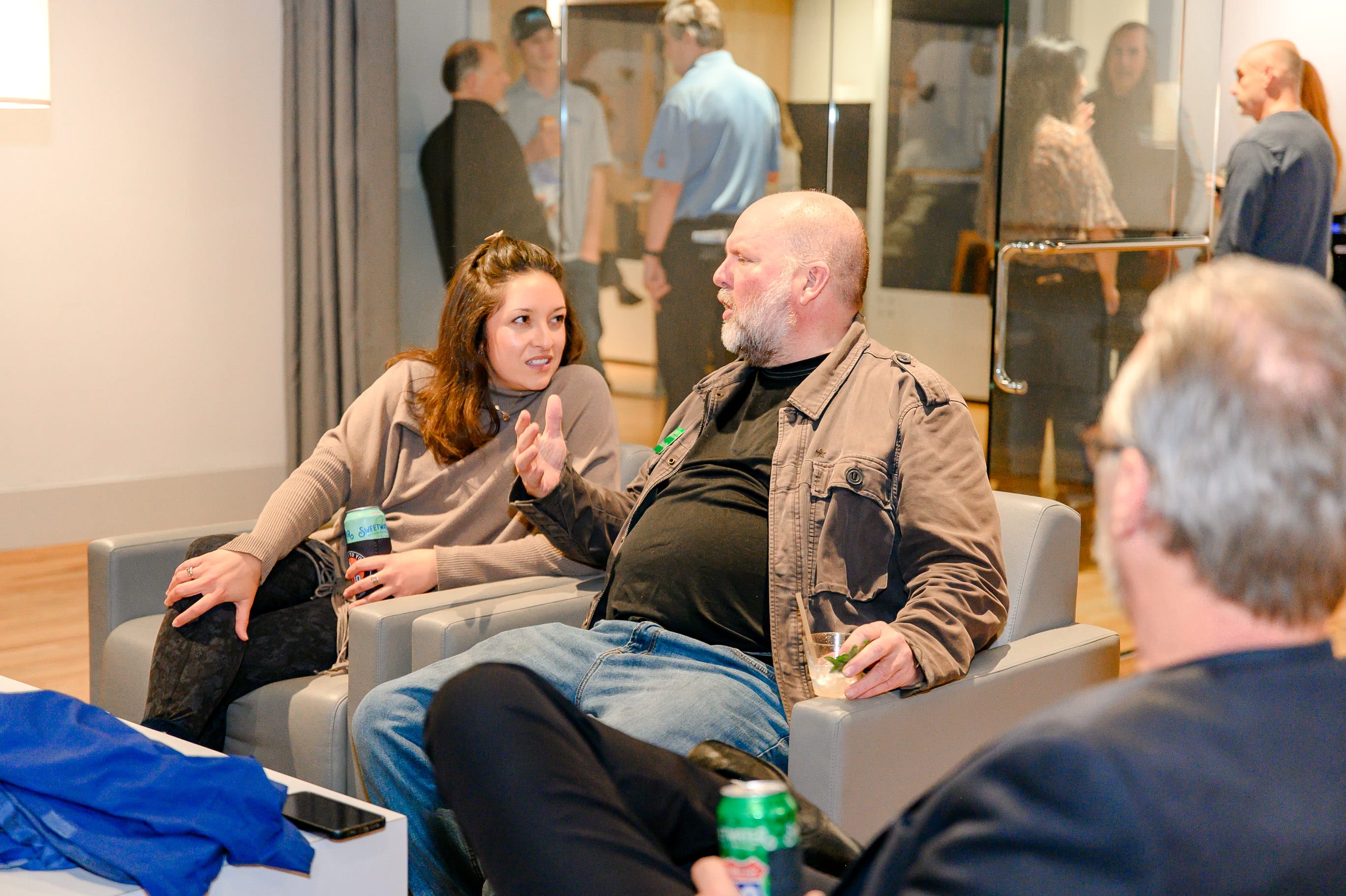 Guests chatting and socializing in a comfortable coworking space during a networking event.